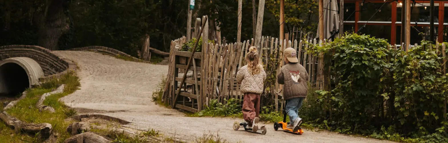 Twee kindjes op de step bij knoest op geversduin